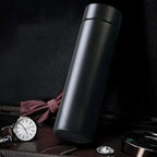 Smart insulated water bottle in matte black displayed with luxury accessories.