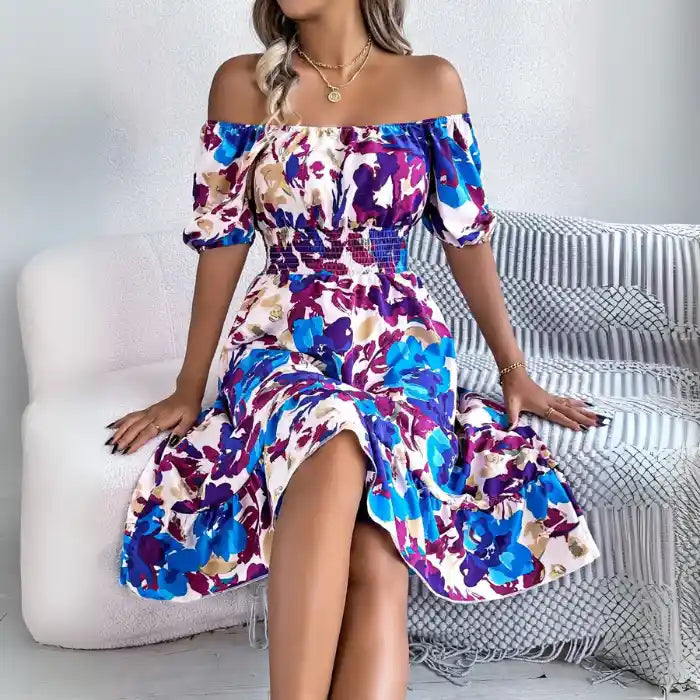 Smocked off shoulder floral midi dress in blue purple print worn seated for casual scene.