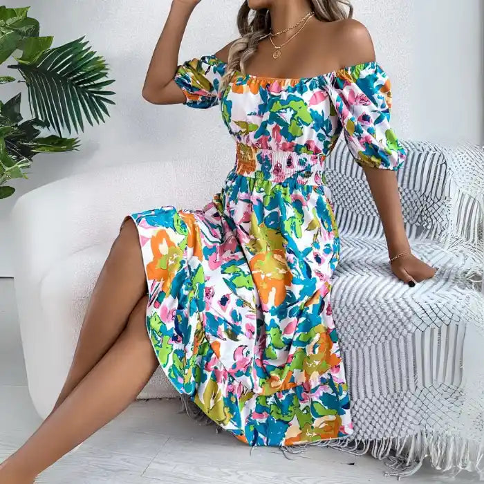 Smocked off shoulder floral midi dress in green orange print showing flowy ruffle hem.