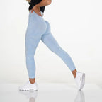 Snowflake yoga pants in light blue with seamless contour fit, shown in athletic side stretch pose.