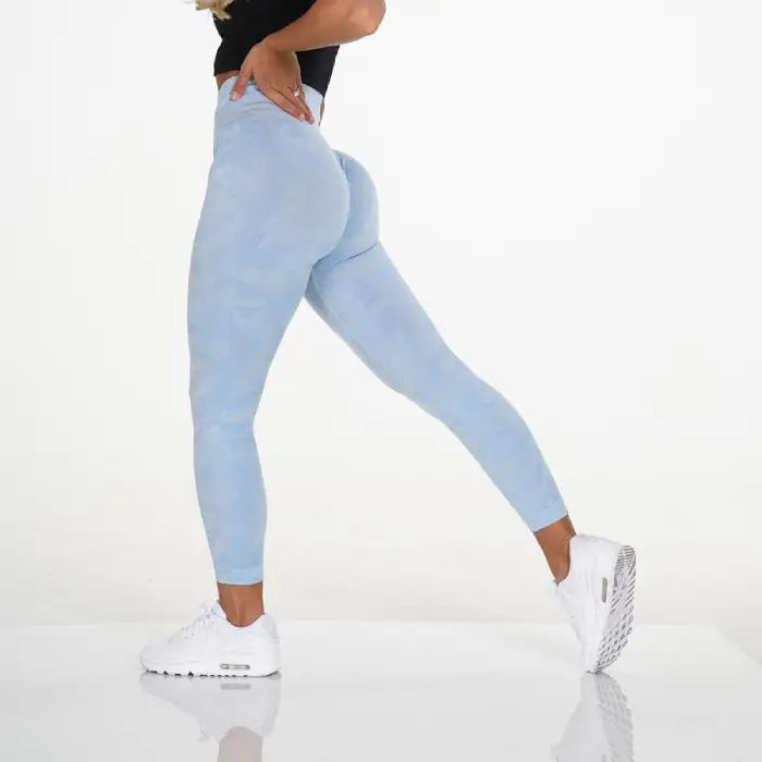 Snowflake yoga pants in light blue with seamless contour fit, shown in athletic side stretch pose.