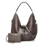 Soft leather hobo bag with perforated detail in black, closeup highlighting crescent shape and leather texture.