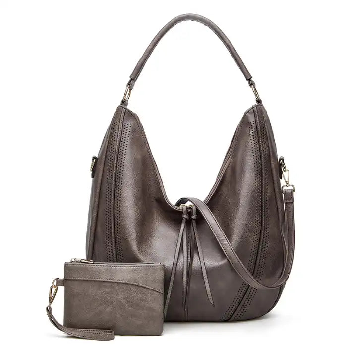 Soft leather hobo bag with perforated detail in black, closeup highlighting crescent shape and leather texture.