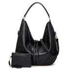 Soft leather hobo bag with perforated detail in black color, front view with matching pouch and shoulder strap.