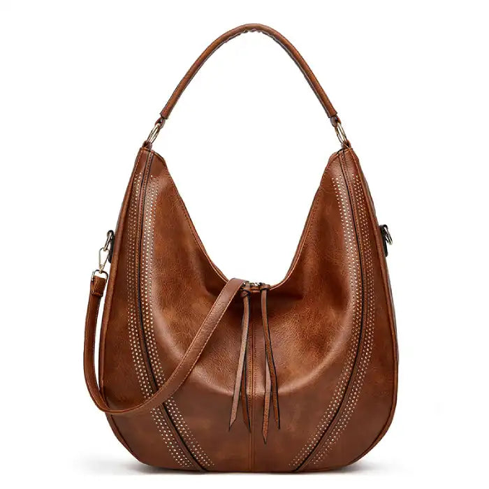  Soft leather hobo bag with perforated detail in brown, closeup showing crescent shape and drawstring closure.