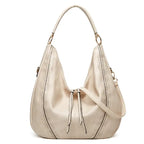 Soft leather hobo bag with perforated detail in cream, closeup showing drawstring closure and leather texture.