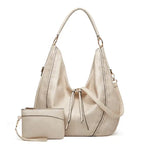 Soft leather hobo bag with perforated detail in cream color, front view with matching pouch and shoulder strap.