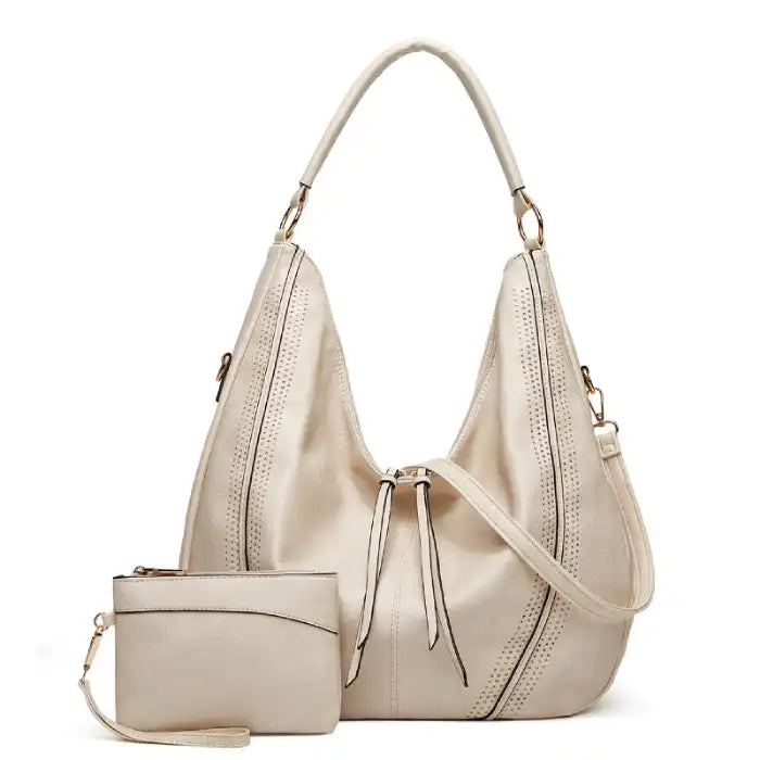 Soft leather hobo bag with perforated detail in cream color, front view with matching pouch and shoulder strap.