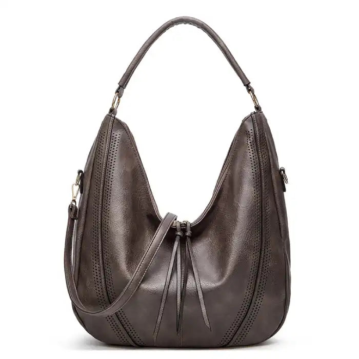 Soft leather hobo bag with perforated detail in gray, closeup showing slouchy crescent shape and drawstring.