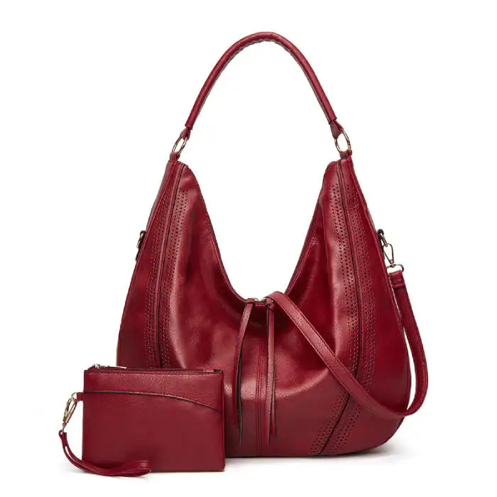 Soft leather hobo bag with perforated detail in red color, front view with matching pouch and shoulder strap