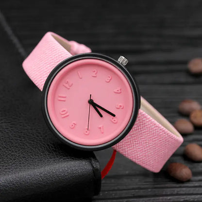 Light pink wristwatch with minimalist design and embossed numbers for a soft, modern accessory.