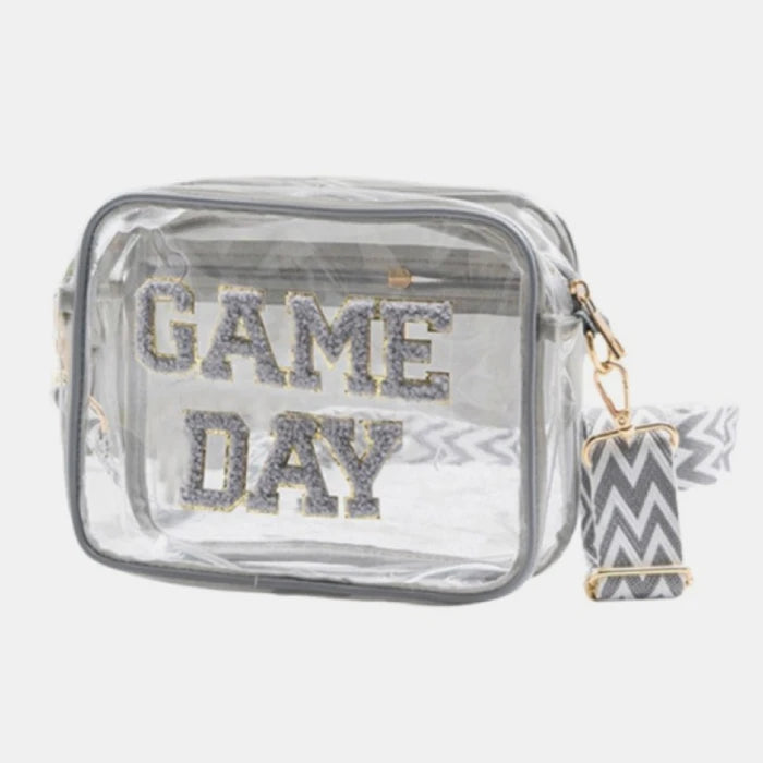 Clear vinyl purse with glittery silver "GAME DAY" lettering and black-white geometric pattern strap for stadium security compliance