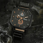 square leather strap watch positioned on stone surface showing black dial with copper markers, luxury men’s analog watch design detail