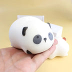 Squeeze toy panda held in hand showing soft and squishy design with black and white features.