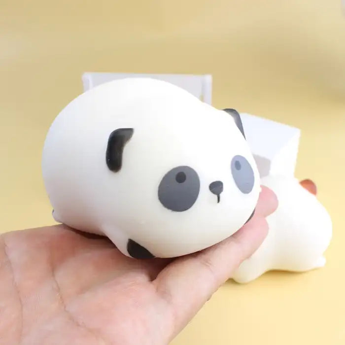 Squeeze toy panda held in hand showing soft and squishy design with black and white features.