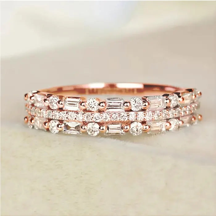 Stackable ring set in rose gold with sparkling baguette crystals and layered bands offering elegant romantic style for fashion-loving buyers