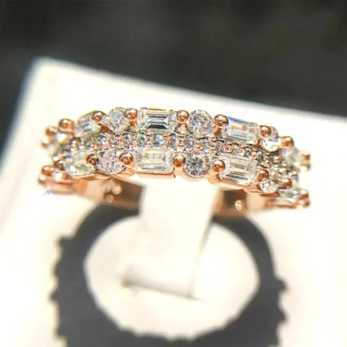 Stackable ring set in rose gold under showcase lighting with dazzling baguette crystals offering elegant sparkling layered luxury style for shoppers