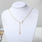 Star Moon Choker gold necklace with moon pendant and dangling star displayed on white jewelry stand
