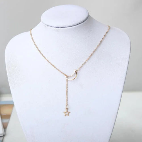 Star Moon Choker gold necklace with moon pendant and dangling star displayed on white jewelry stand
