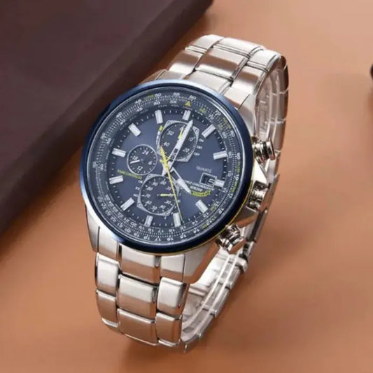 Luxury chronograph watch with silver stainless steel bracelet photographed on brown surface showing blue dial detail