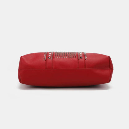 Durable structured bottom of red leather tote with continued studded pattern detail for lasting luxury bag construction