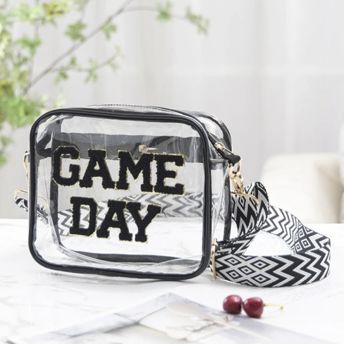 Lifestyle photo of clear stadium bag with "GAME DAY" text styled with greenery and cherries on white marble surface