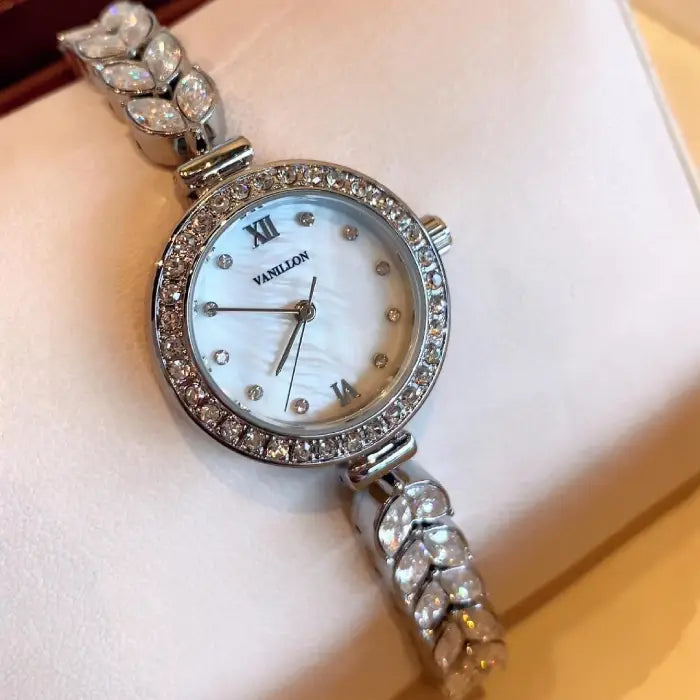 Luxury silver stylish bracelet watch with a diamond-studded bezel and intricate bracelet design.