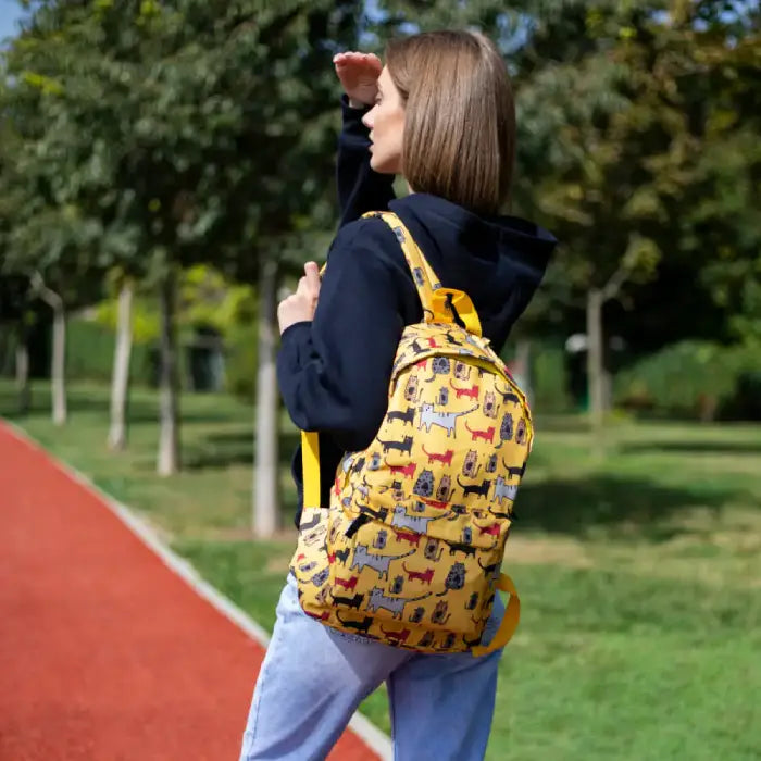 Yellow cat backpack modeled outdoors, showing its vibrant design and practical size for daily use.