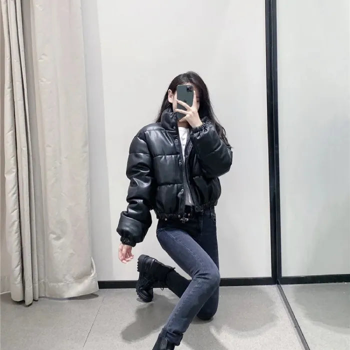 Stylish puffer jacket in black worn by model with jeans and boots in mirror selfie