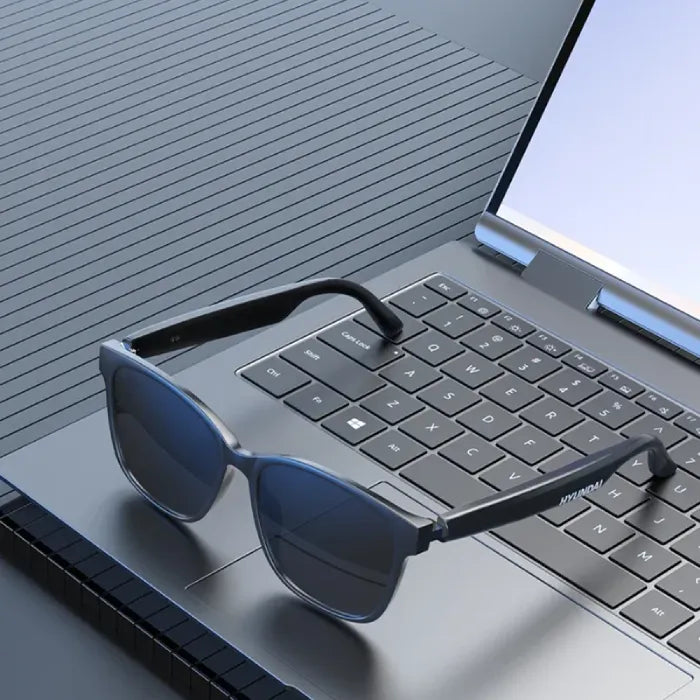 Stylish smart glasses on modern laptop keyboard for AI-powered tasks.