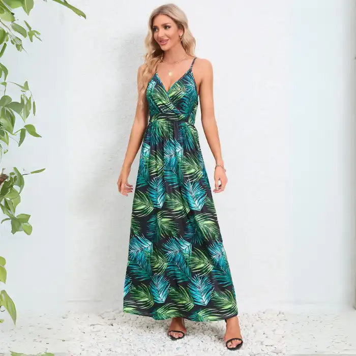 Summer dress with tropical palm leaf pattern in teal and green tones, featuring adjustable straps and fitted waist for resort wear