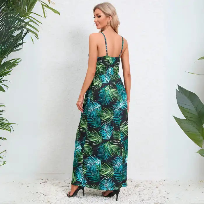 Summer dress in colorful tropical print showing back view with thin spaghetti straps and flowing maxi silhouette
