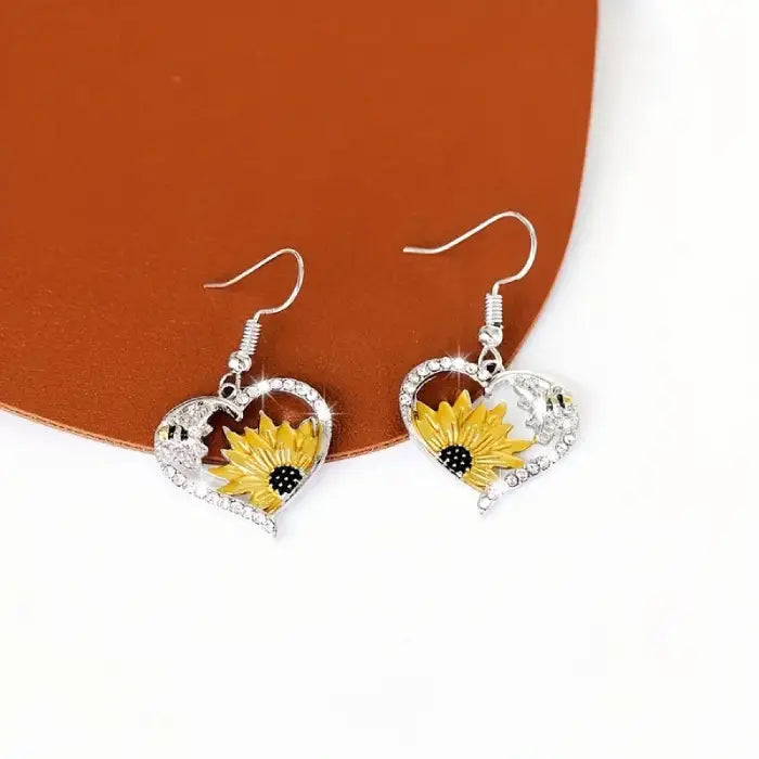 Elegant sunflower heart earrings with bee accents showcased on a modern backdrop for jewelry lovers.