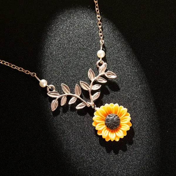sunflower pendant necklace for women shown in a dramatic close up with detailed floral leaves and warm lighting for elegant jewelry appeal