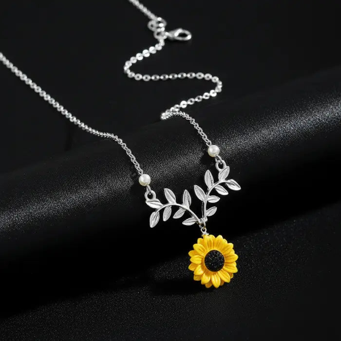 sunflower pendant necklace for women shown in silver with bright floral detailing on black for a refined elegant feminine jewelry style