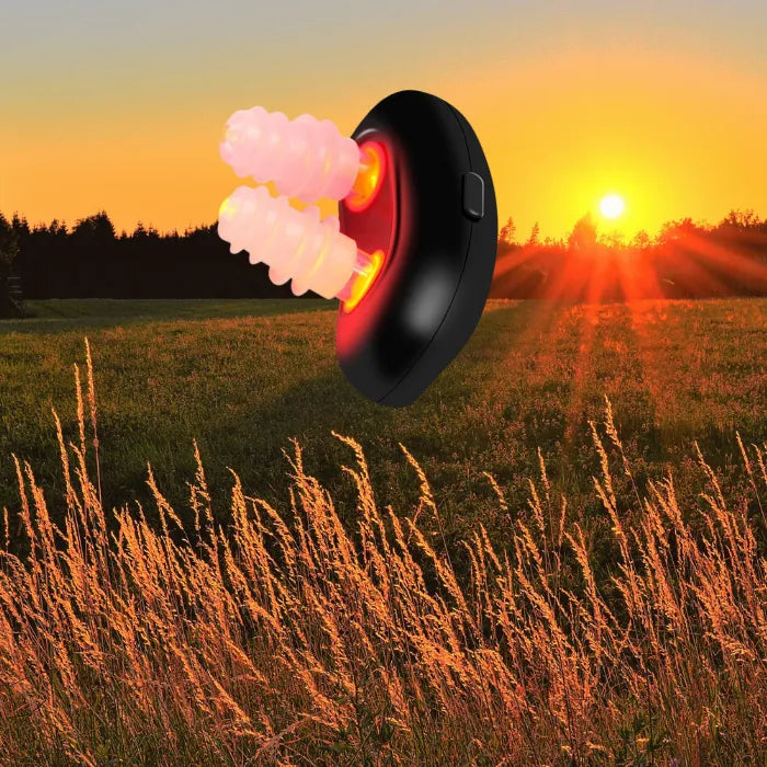 Innovative red light nasal therapy device aglow at sunset in a tranquil meadow.