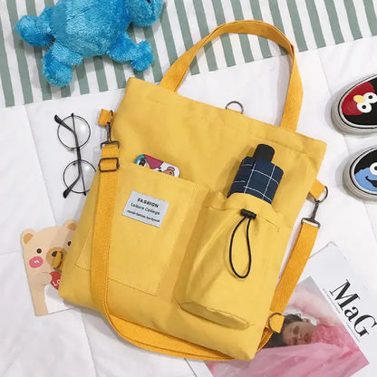 Yellow canvas tote bag styled with round glasses and character sneakers on striped background