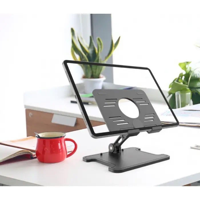 Tablet stand on white table in modern office with blue walls, wooden chairs, and wall-mounted display.