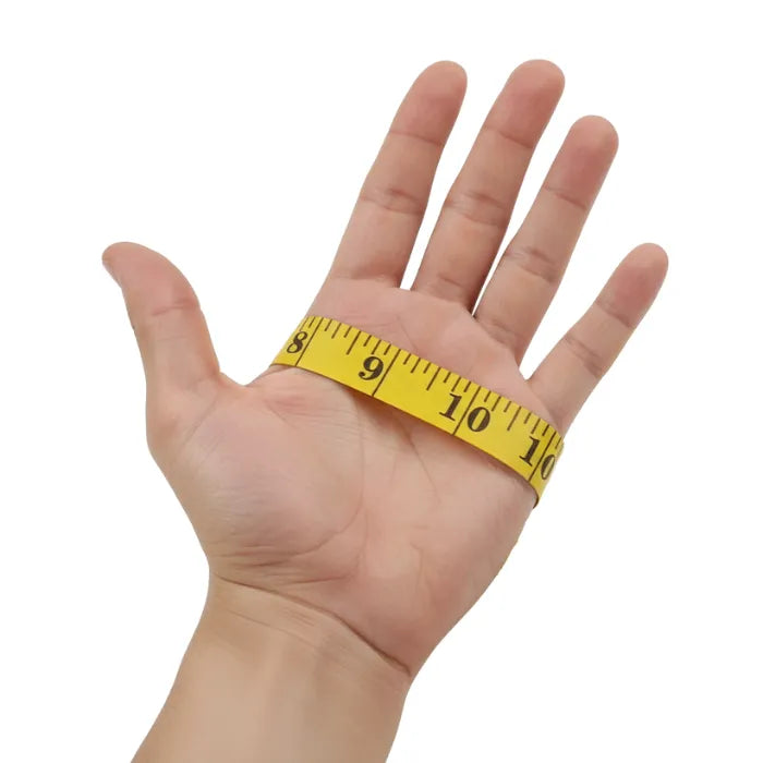 Hand with a yellow measuring tape around the wrist on a white background