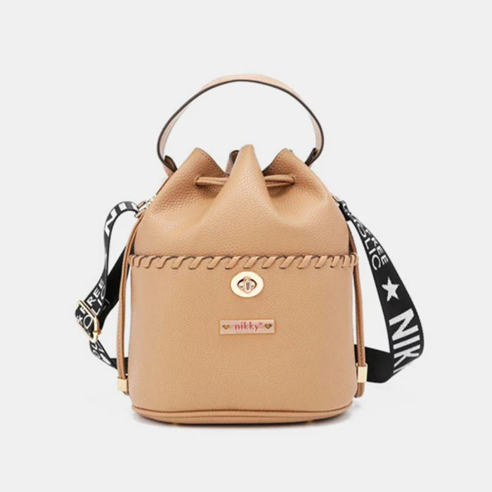 Luxury tan leather bucket bag by Nikky with signature braided trim detail and adjustable black logo strap