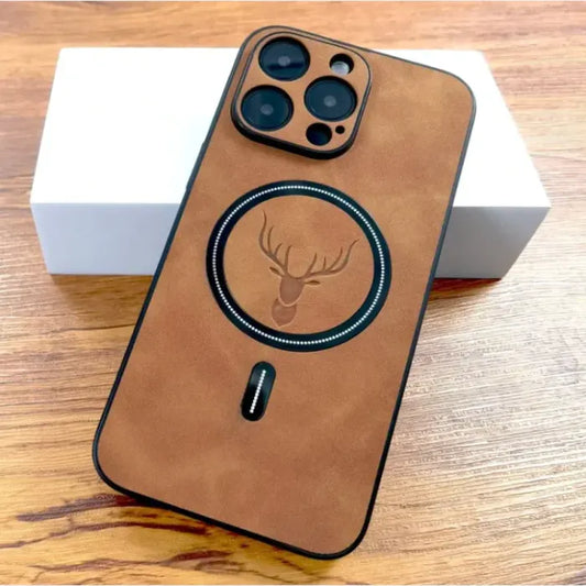 Tan suede iPhone case with deer logo and MagSafe ring, displayed on wood.