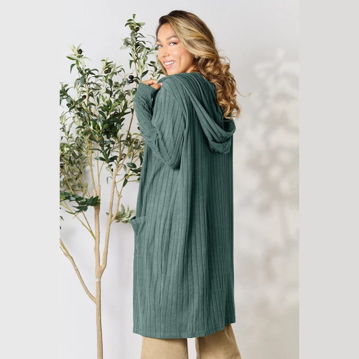 Forest green ribbed cardigan back view showing hood detail and full-length silhouette paired with khaki pants