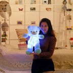 Teddy Bear glowing blue plush held by a woman in a warm indoor setting.