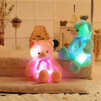 Teddy Bear glowing pink and blue plush toys sitting near a bed.