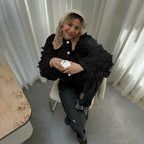 Textured loop knit cardigan jacket in black from overhead angle, showing looped texture with casual outfit styling.