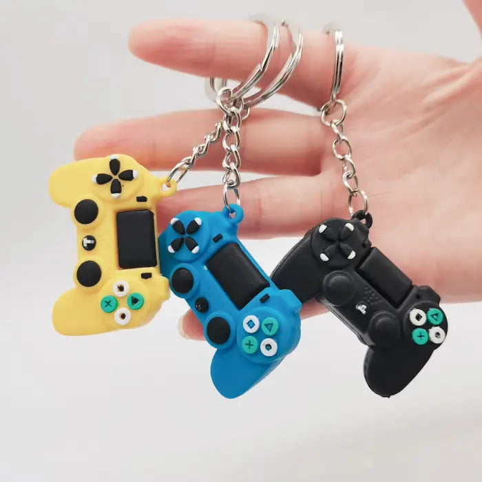 Blue, yellow, and black game controller keychains held in hand, perfect for fun gaming-inspired gifts.