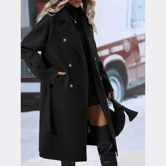 Black wool trench coat with metallic buttons and belt, styled with turtleneck and thigh-high boots for winter