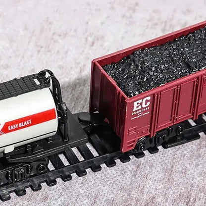 Close-up of toy train cargo cars carrying coal and a tanker labeled "Easy Blast."