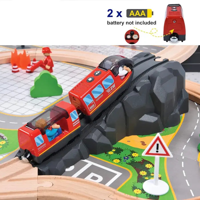 Red toy train on a mountain track, powered by two AAA batteries, with a warning sign on the layout.