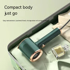 Travel steamer in green fits compactly in suitcase beside folded clothes and perfume bottle.